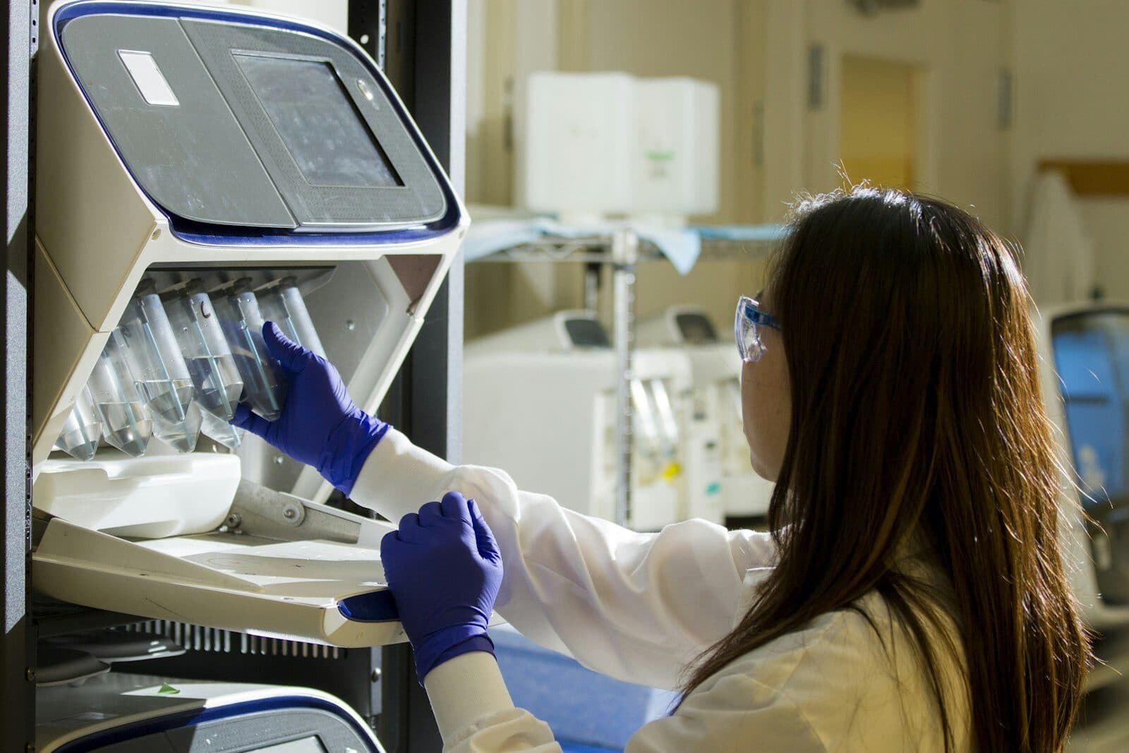 Medical laboratory technician handling specimen equipment